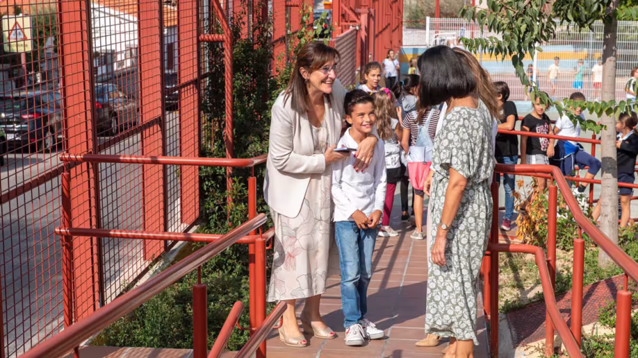 La alcaldesa junto a un niño en la puerta de un colegio